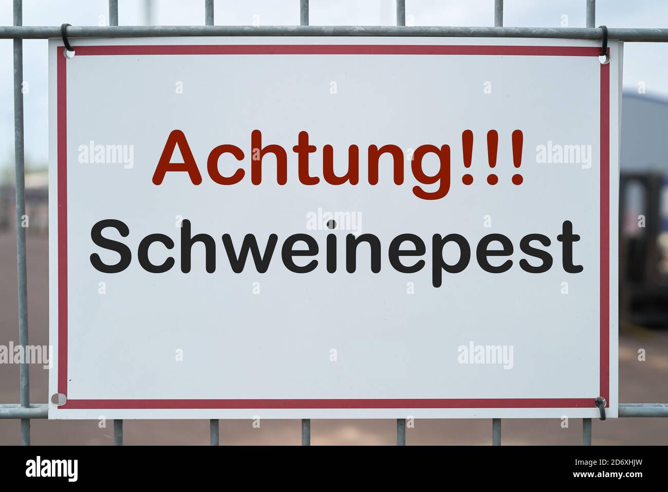 Sign with the inscription 'Achtung Schweinepest' (Attention African swine fever) on a fence to a farm in Germany Stock Photo