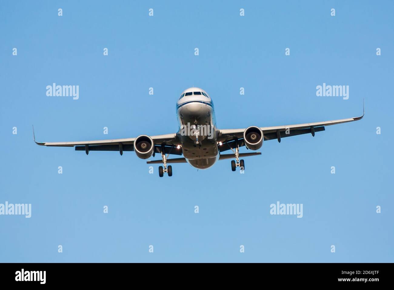 Passenger aircraft in flight with landing gear released on blue sky ...