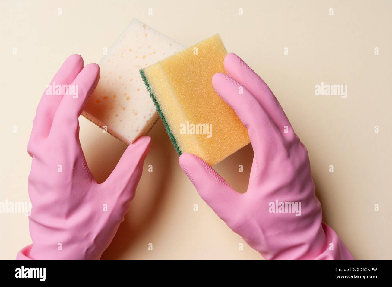Hands in rubber gloves holding sponges for cleaning. Stock Photo