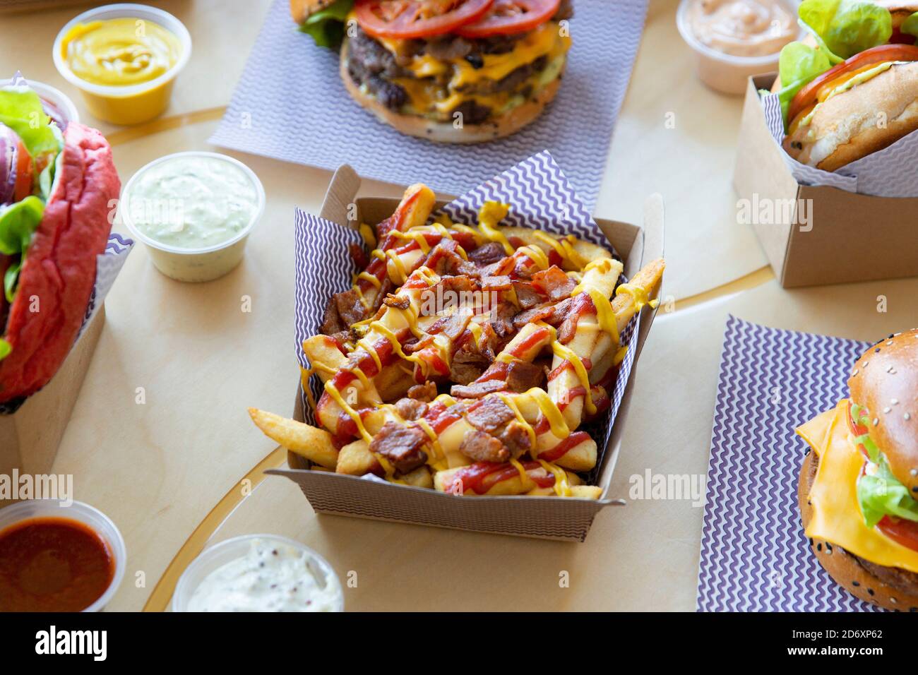 Take out burger restaurant table setting with poutine cheese & bacon loaded fries. Stock Photo