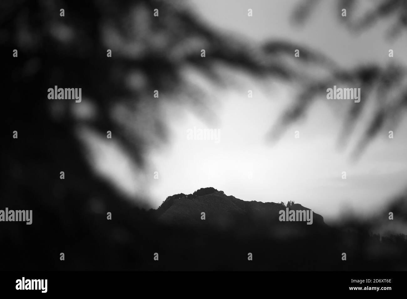 Black and white photograph of mountain peak with shadows in the foreground Stock Photo