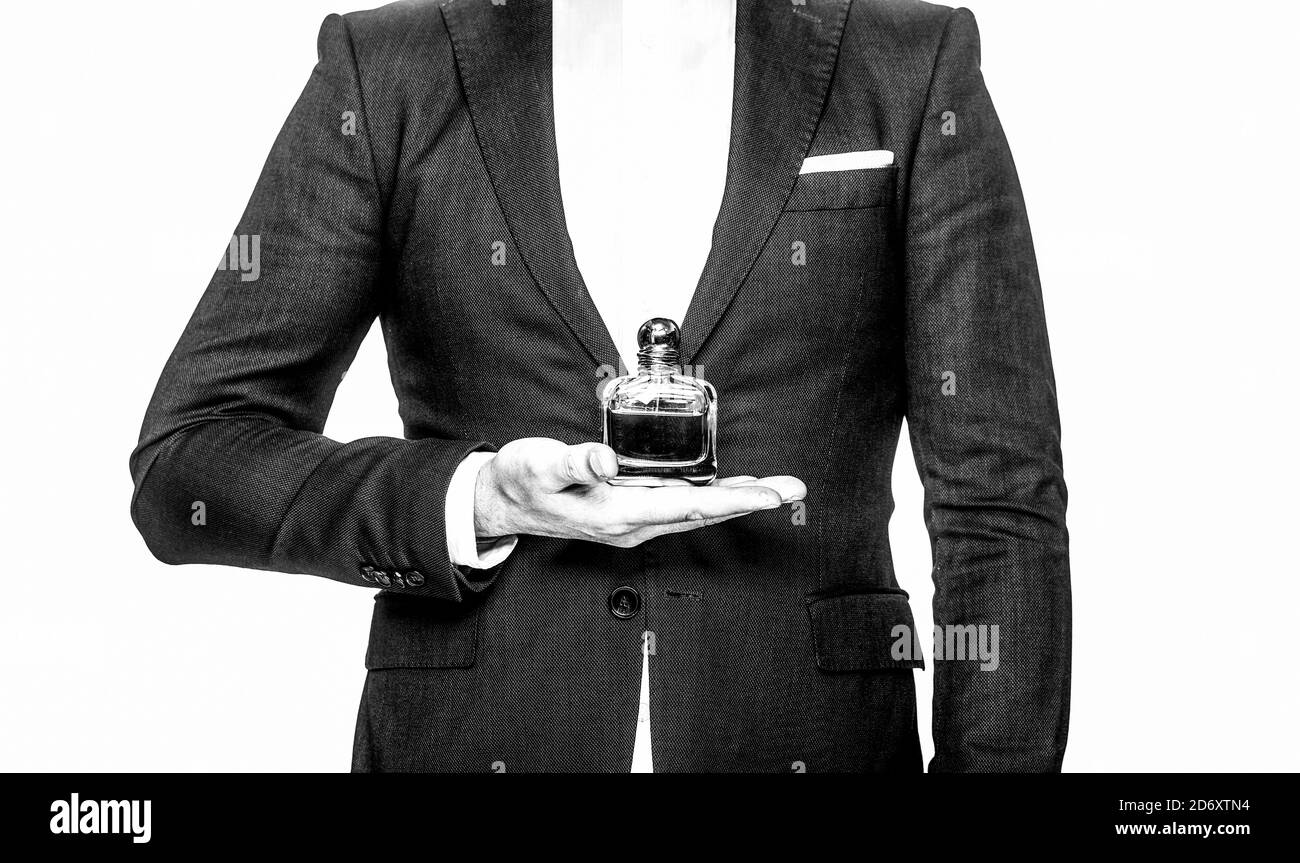 Perfume or cologne bottle and perfumery, cosmetics, scent cologne bottle, male holding cologne. an in a suit holding a bottle of perfume isolated on Stock Photo