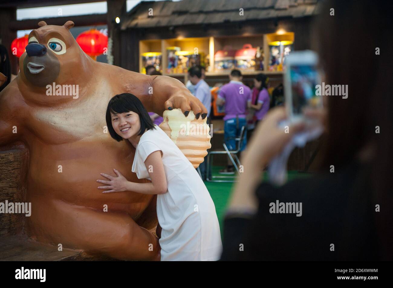 (201020) -- SHENZHEN, Oct. 20, 2020 (Xinhua) -- A visitor poses for a photo with a domestically designed animation figure during the 10th China (Shenzhen) International Cultural Industries Fair in Shenzhen, south China's Guangdong Province, May 16, 2014. Along with 40 years of rapid economic growth, Shenzhen, China's first and most successful special economic zone, has also achieved cultural prosperity. As early as 2003, Shenzhen took the lead in proposing the strategy of making the city culture-nurtured. In 2008, Shenzhen was designated as a UNESCO City of Design, clarifying the transformati Stock Photo