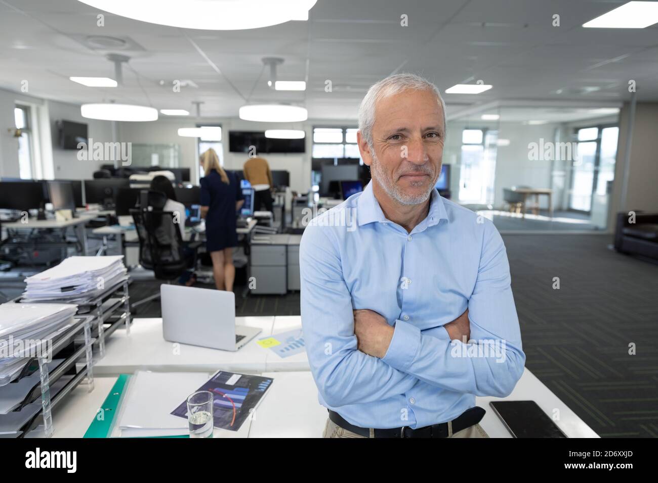 Portrait of senior businessman with arms crossed at modern office Stock ...