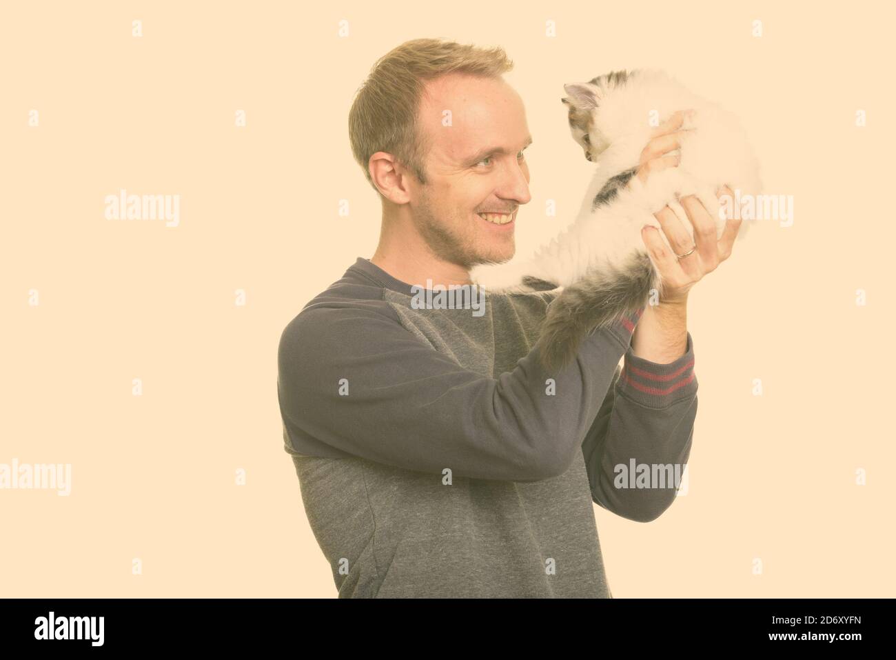 Happy handsome Caucasian man holding cute kitten Stock Photo