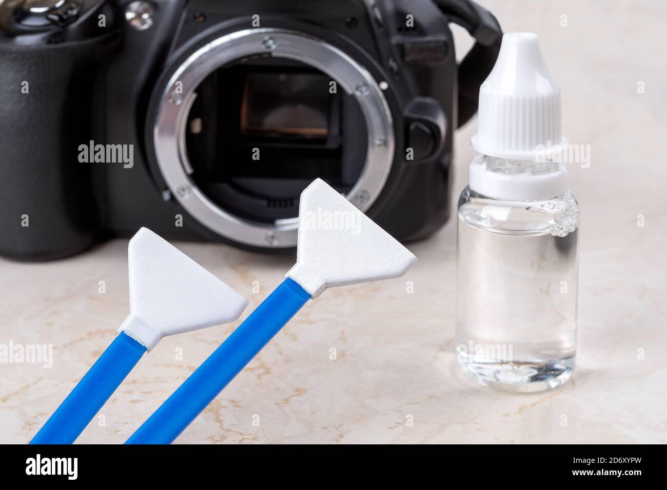 Liquid sensor cleaner and two swabs against dslr camera with lens