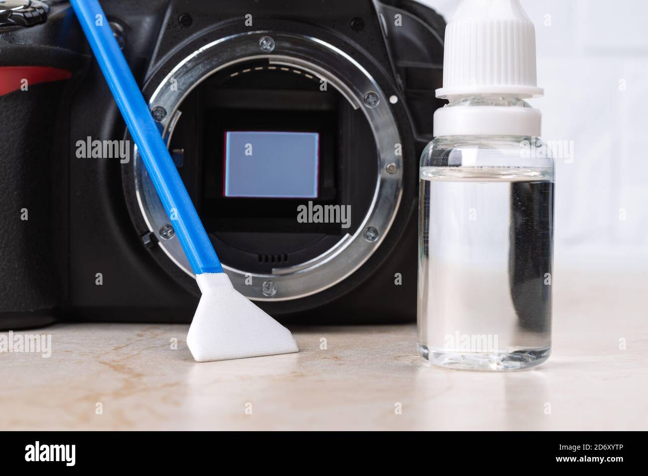Dslr camera with raised mirror, liquid sensor cleaner and swab on a