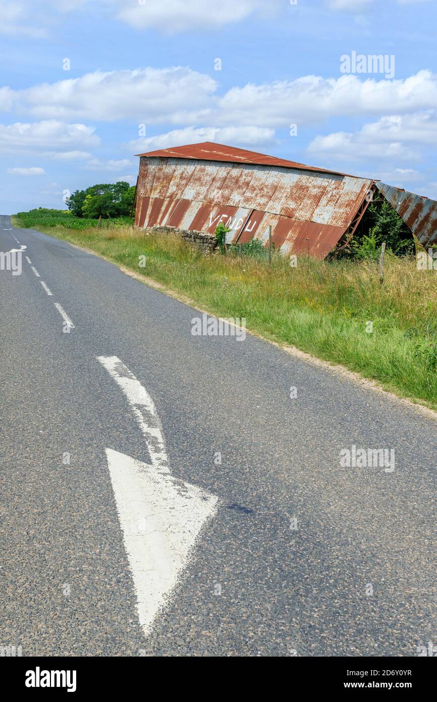 France, Loir et Cher, ruined agricultural hangar in sheet metal at the edge of a road // France, Loir-et-Cher (41), hangar ruiné en tôle au bord d'une Stock Photo
