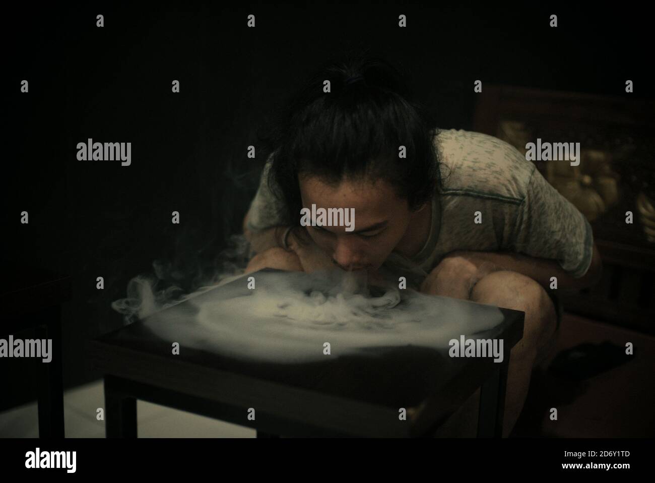 A vaping enthusiast having fun during leisure time, creating 'tornado shape' using e-cigarette vapours at a vape cafe in Banten province, Indonesia. Stock Photo