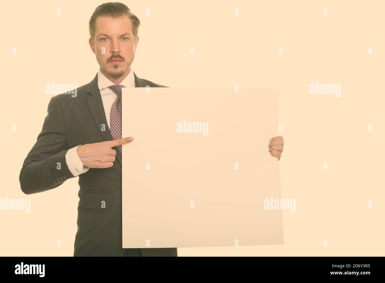 Young handsome Caucasian businessman holding copyspace and pointing finger Stock Photo