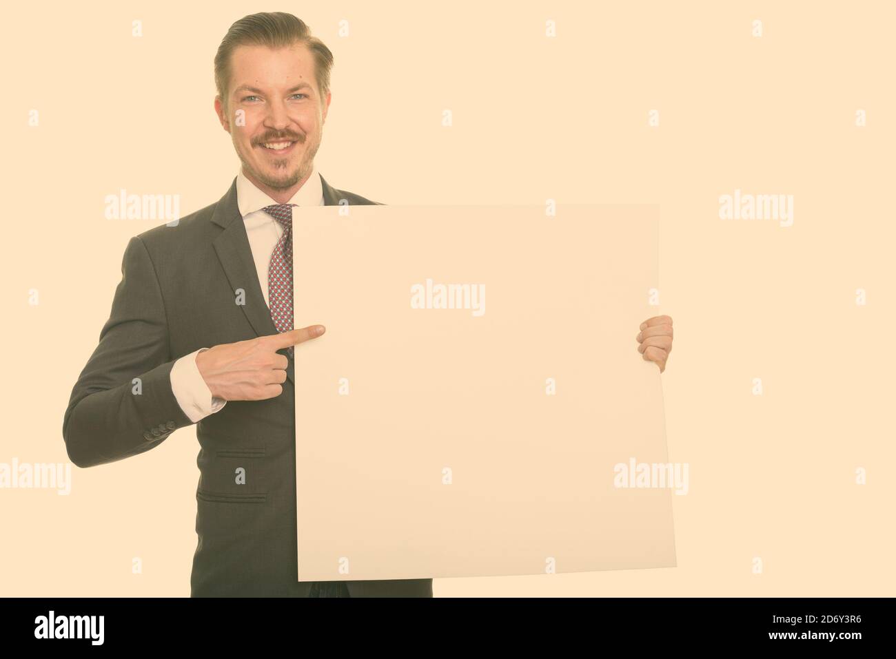 Young happy Caucasian businessman holding copyspace and pointing finger Stock Photo