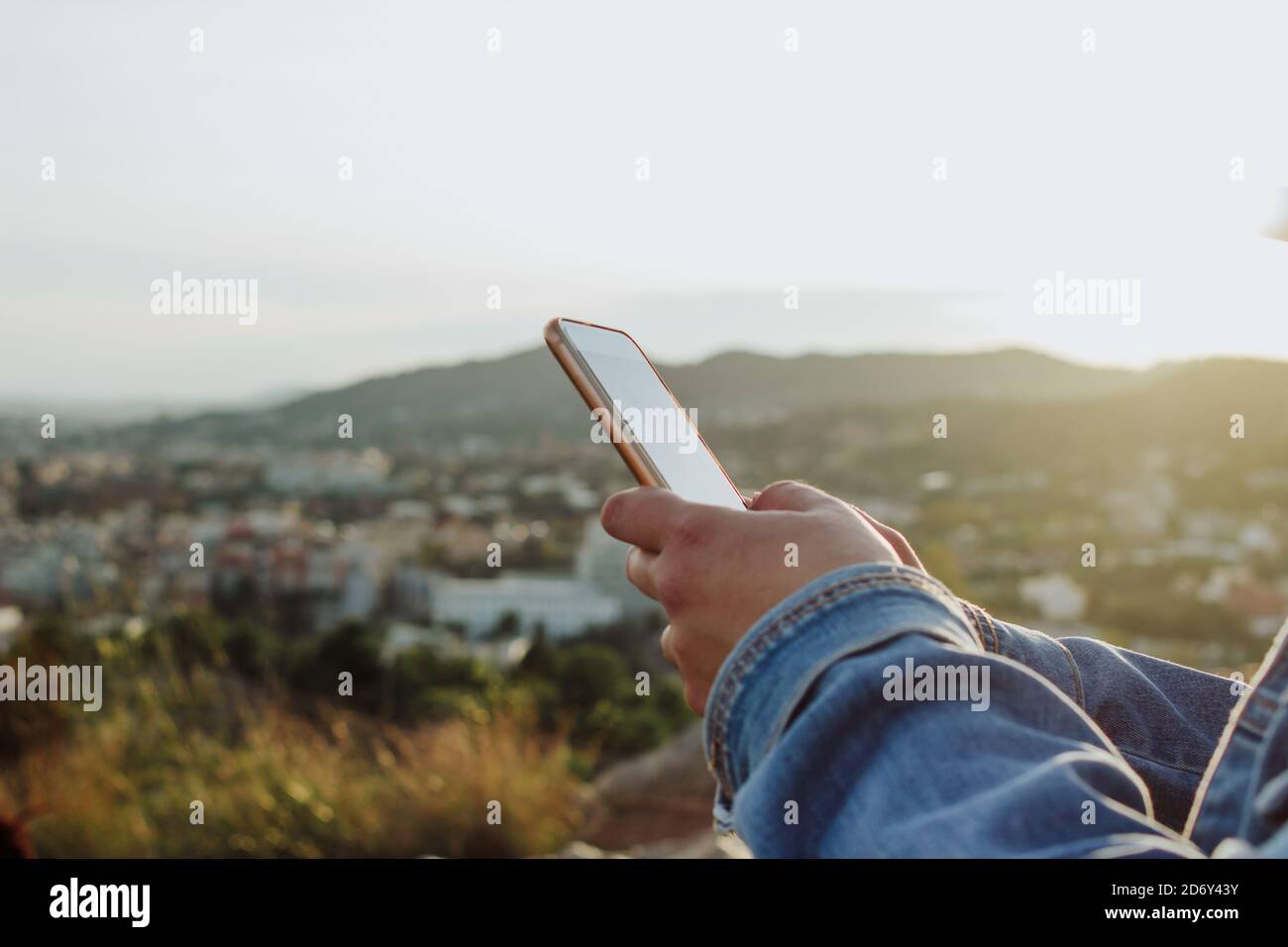 young lady using cell phone on the countryside. Rural internet connectivity concept. Stock Photo