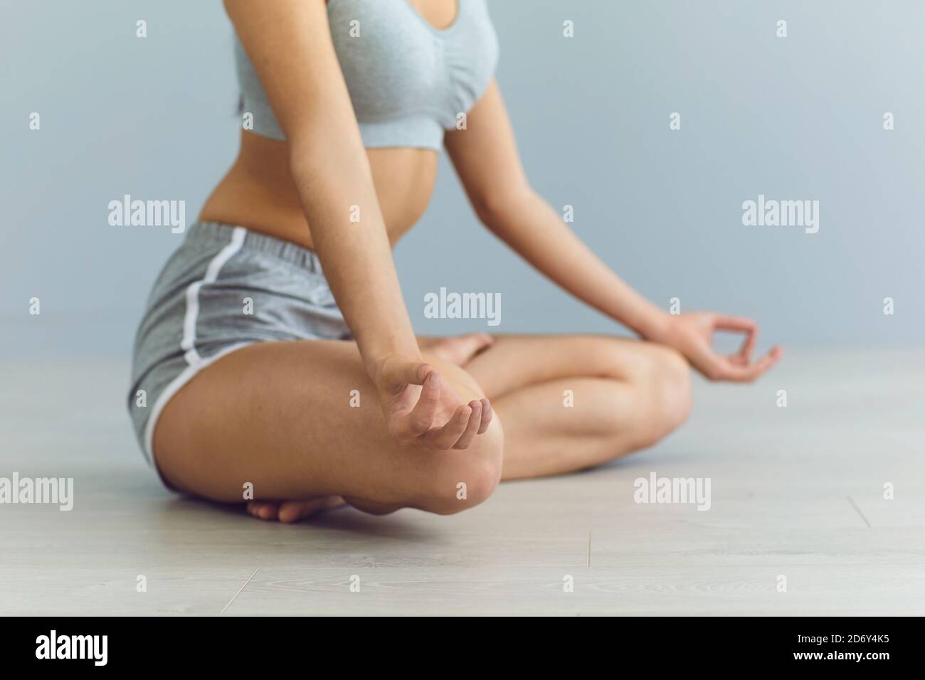Crop woman meditating on floor Stock Photo - Alamy