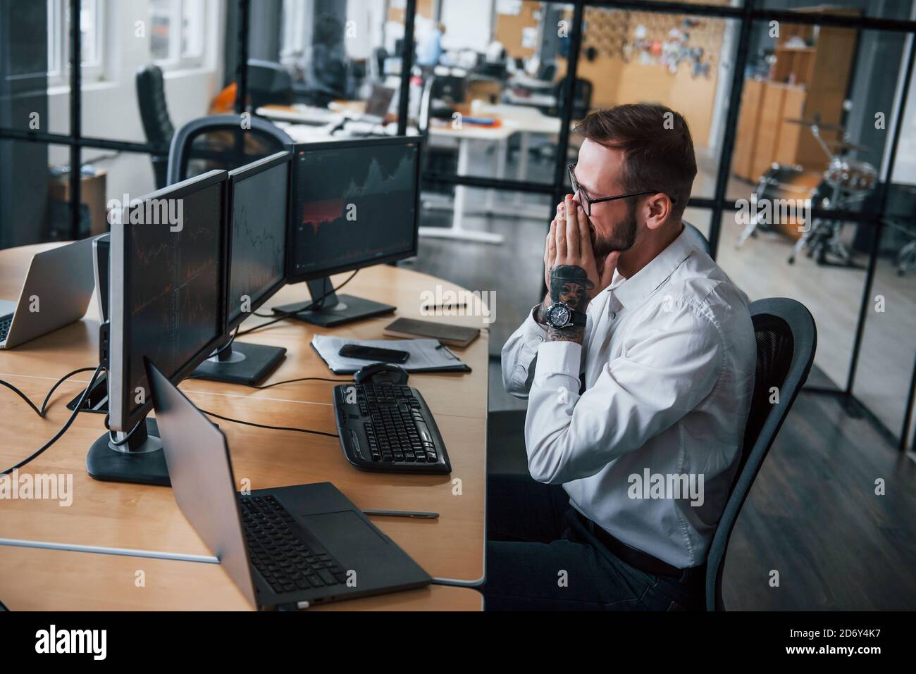 Worried facial expression. Male stockbroker in formal clothes works in