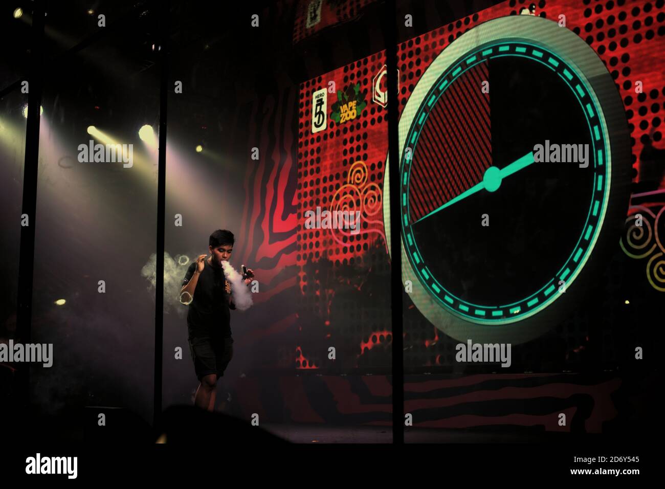 A contestant demonstrating his skills on stage, during a vape cloud trick contest held along with the Annual Vape fair in Jakarta, Indonesia. Stock Photo