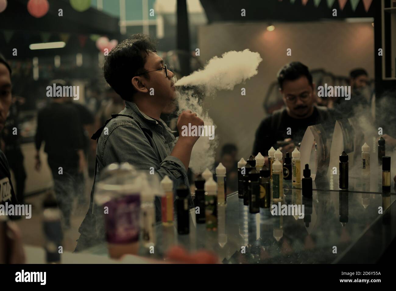 An e-cigarette user trying a liquid before buying at a stall during a vape fair in South Jakarta, Jakarta, Indonesia. Stock Photo
