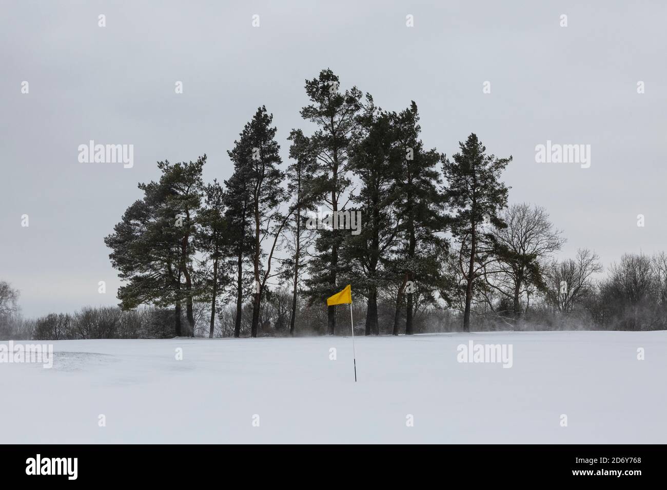 Yellow flag on a snow covered golf course Stock Photo