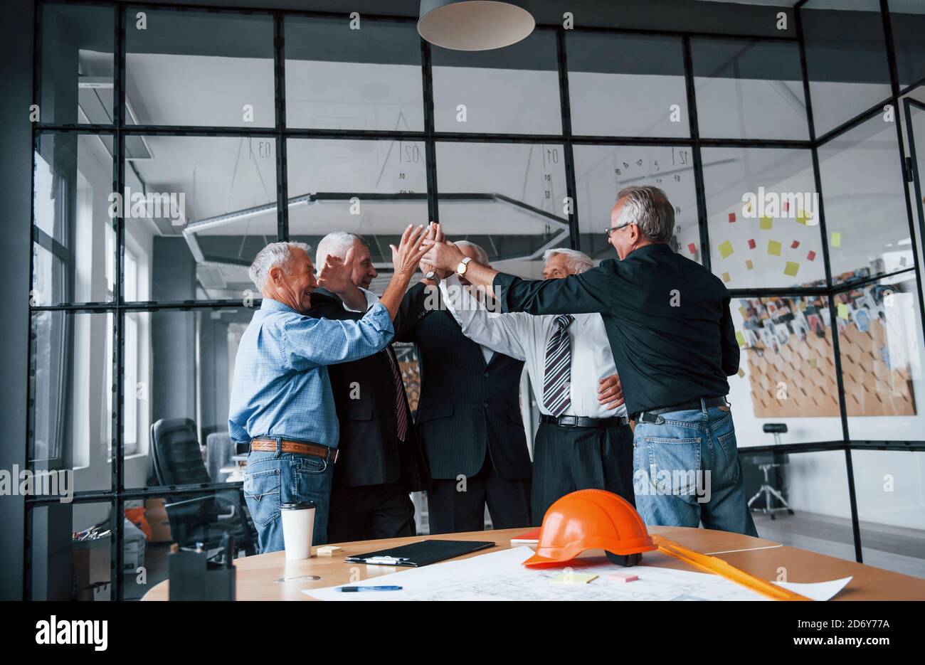 Job Well Done Gives High Five To Each Other Aged Team Of Elderly Businessman Architects Stands In The Office Together Stock Photo Alamy