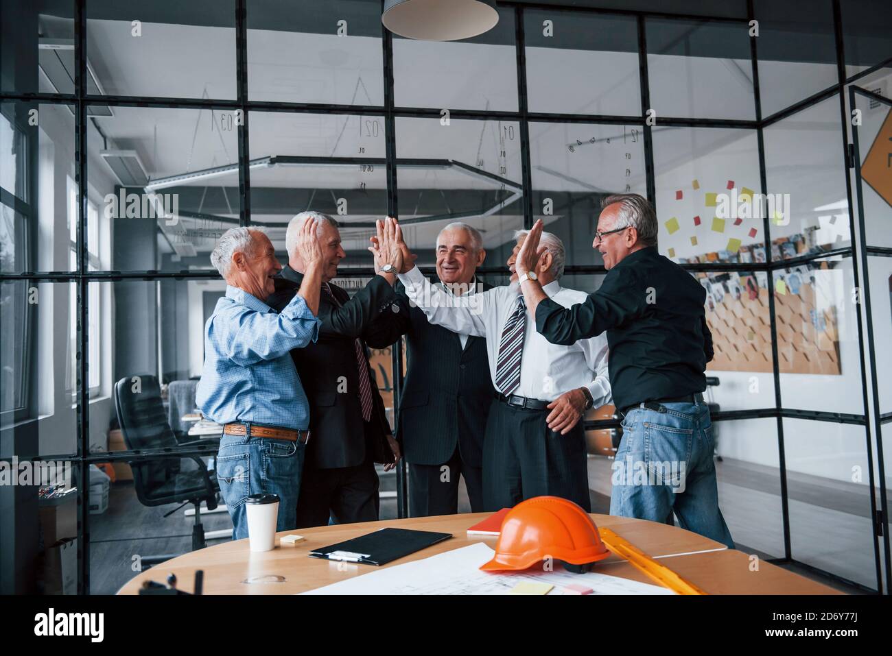 Job Well Done Gives High Five To Each Other Aged Team Of Elderly Businessman Architects Stands In The Office Together Stock Photo Alamy