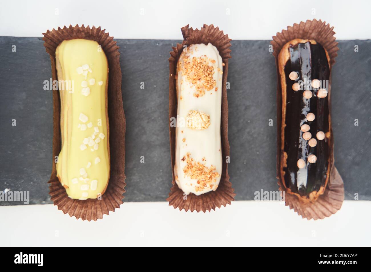 Three eclairs on a black tray top view Stock Photo
