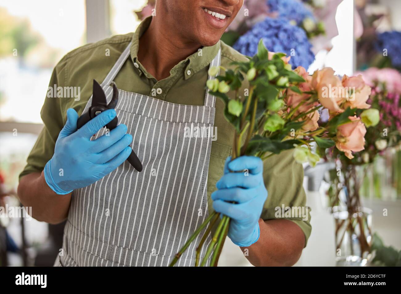 Merry young florist holding bunch of flowers Stock Photo