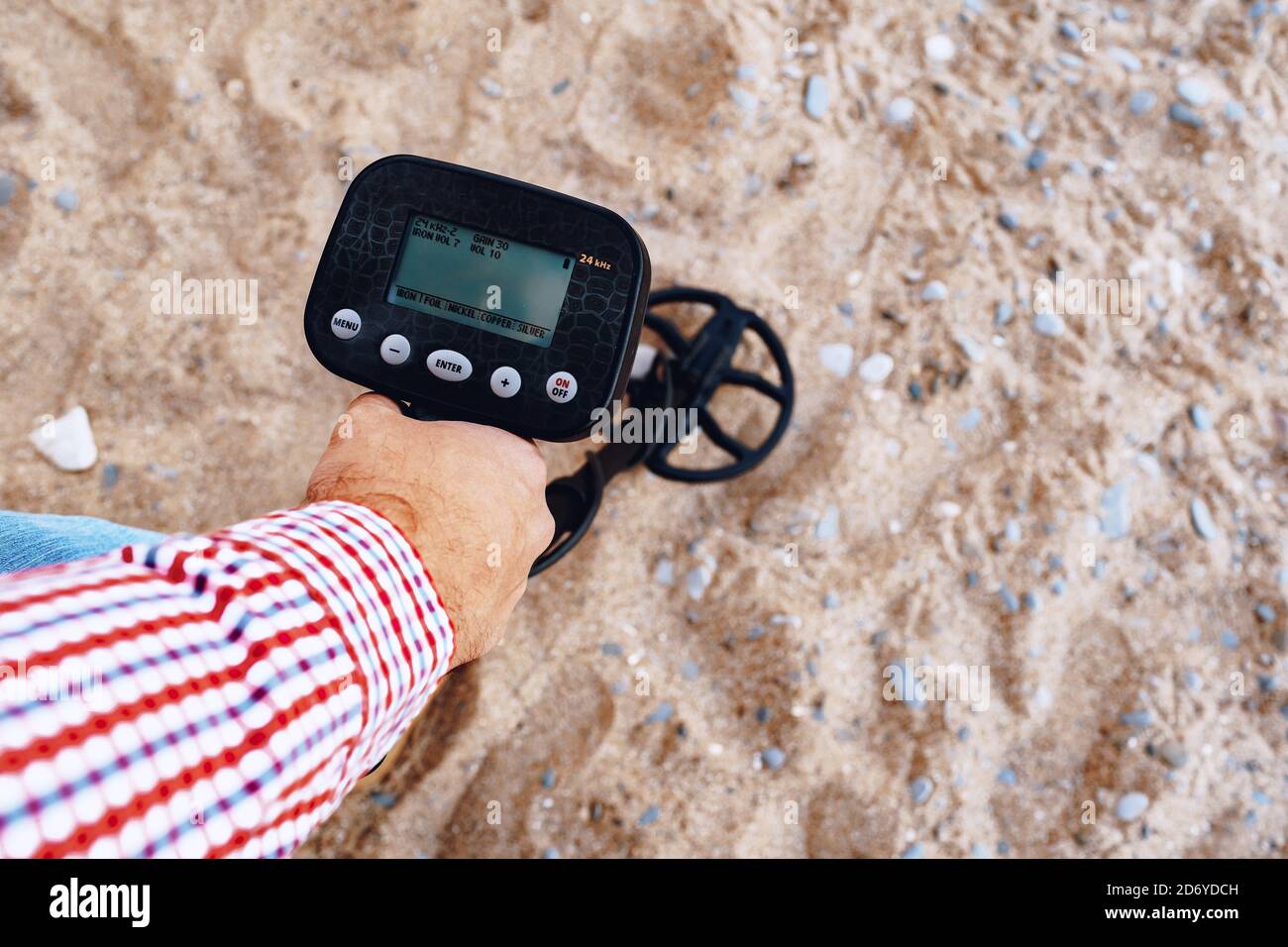 Male hand holding metal detector device above the ground Stock Photo ...