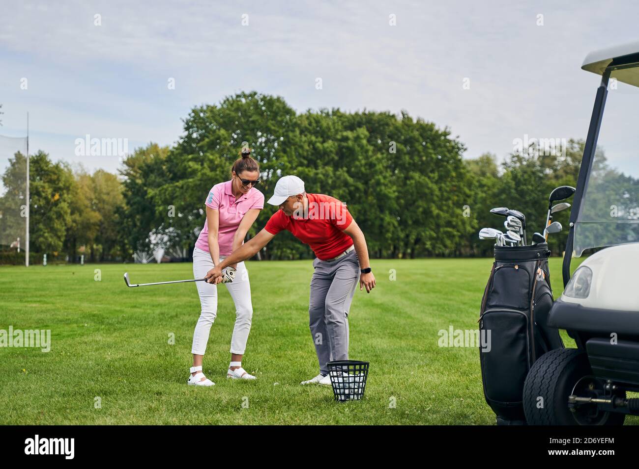 Smiling lady golfer mastering the golf basics Stock Photo