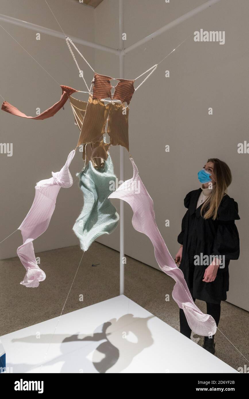 London, UK. 20 October 2020. A staff member views a creation from designer  Rui Zhou's Autumn/Winter Collection Adrift made out of elastic knitted  fabric. Preview of the Beazley Designs of the Year