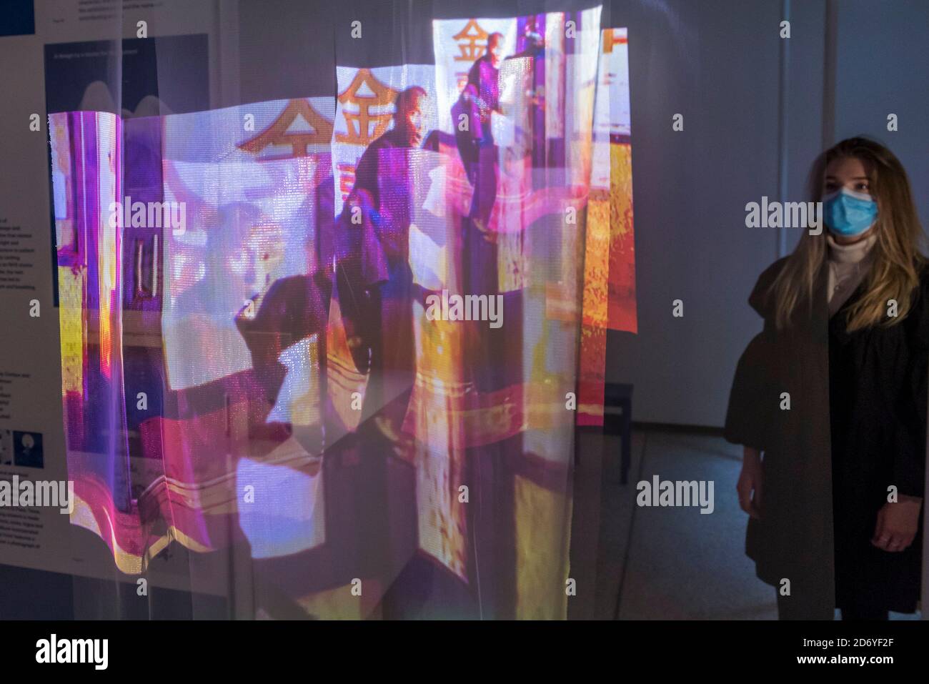 London, UK. 20 October 2020. A staff member views a creation from designer  Rui Zhou's Autumn/Winter Collection Adrift made out of elastic knitted  fabric. Preview of the Beazley Designs of the Year