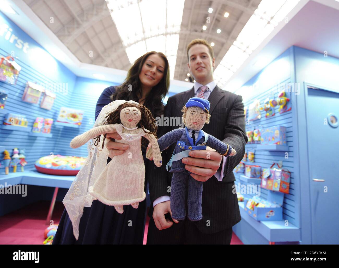 Royal couple lookalikes Kate Bevan and Andy Walker pictured with hand knitted royal couple dolls, at the Galt stand pictured during the Toy Fair at Olympia in west London. Stock Photo