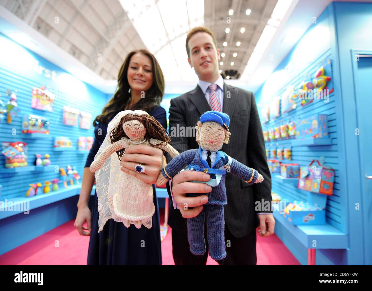Royal couple lookalikes Kate Bevan and Andy Walker pictured with hand knitted royal couple dolls, at the Galt stand pictured during the Toy Fair at Olympia in west London. Stock Photo