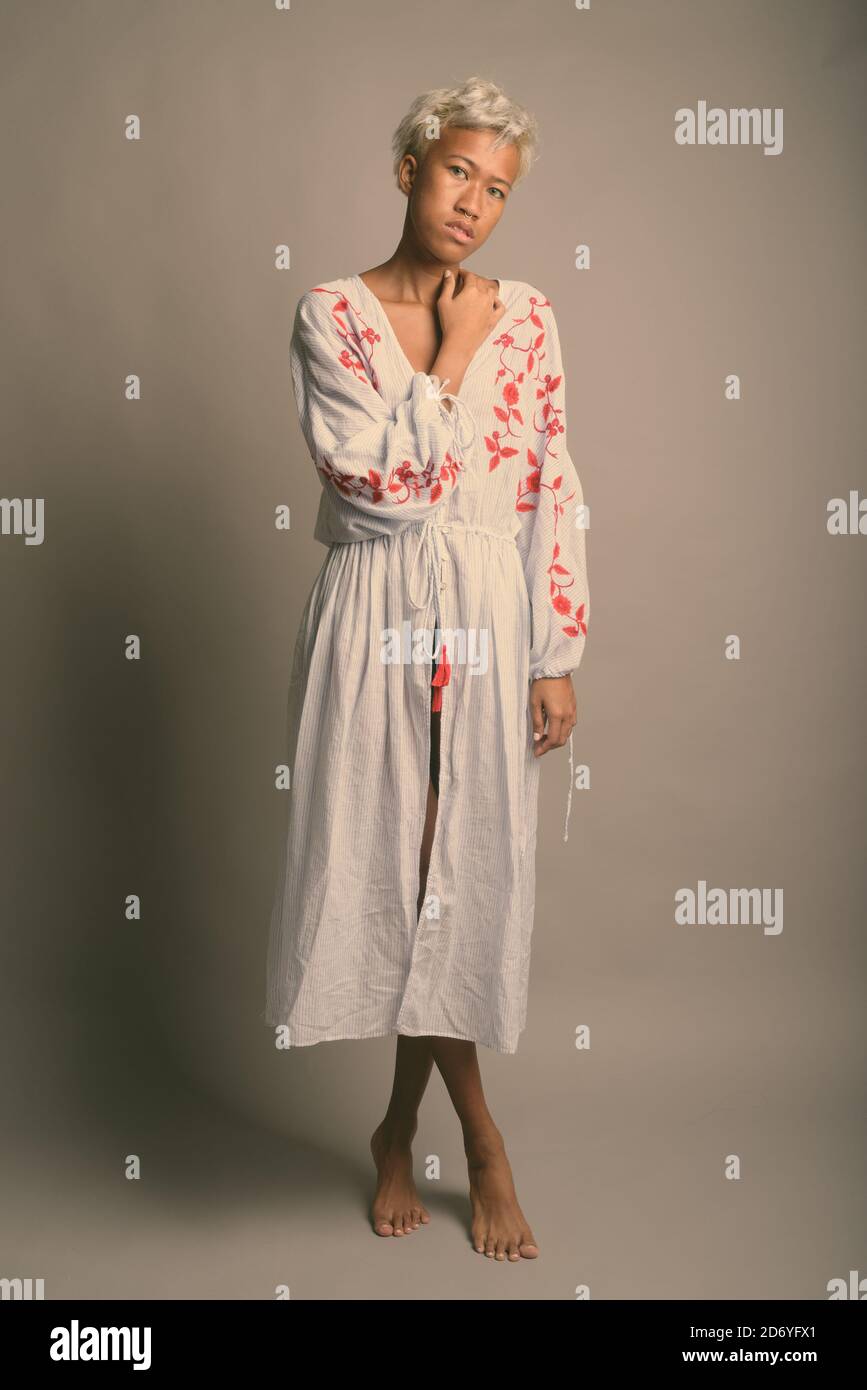 Young beautiful rebellious woman with short hair against gray background Stock Photo