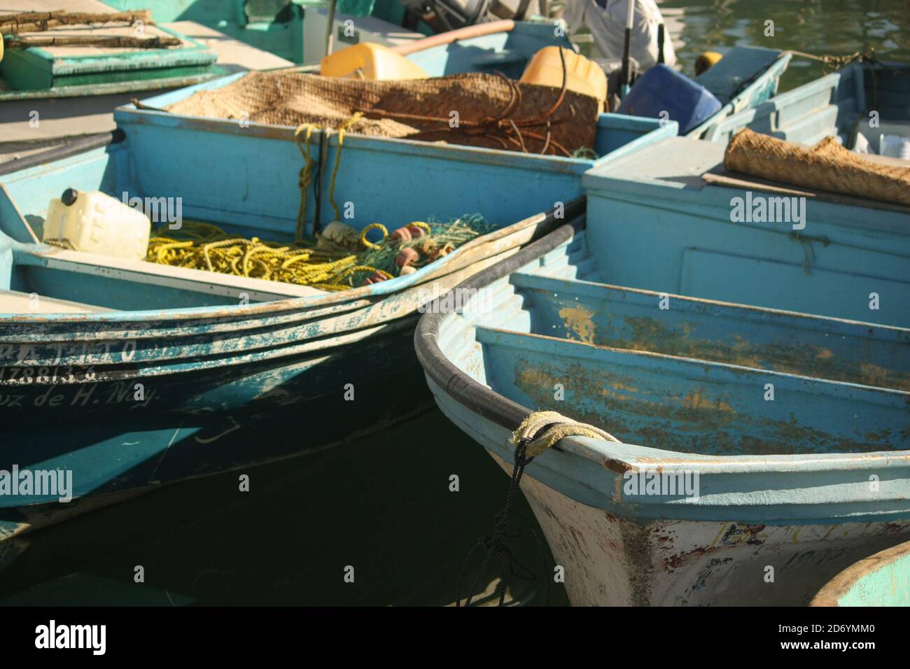 Vintage blue  fishing boats moored in the harbor of La Cruz de Hunacaxtle, Mexico. The morning sun and the sea are ready for the Early Bird. Stock Photo
