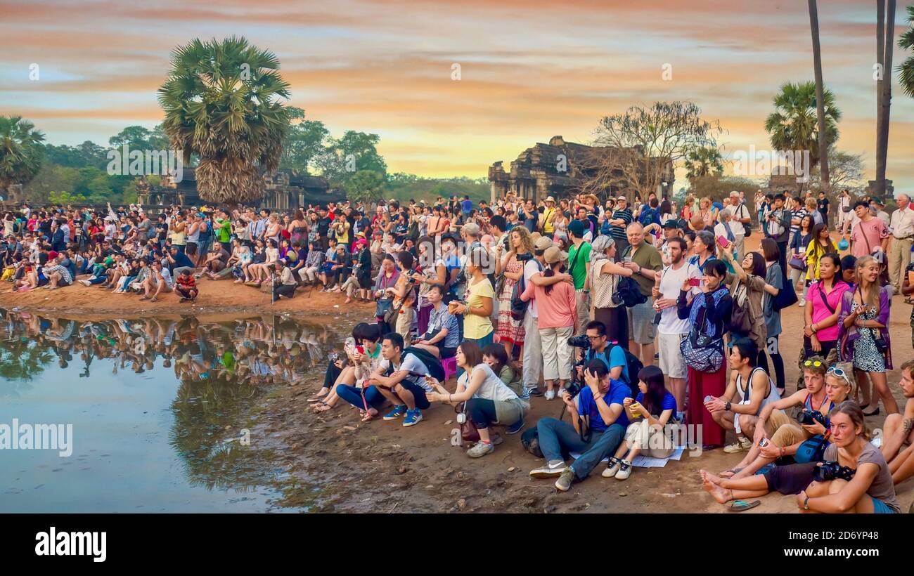 Siem Reap, Cambodia - Mar 3, 2012. A crowd of international tourists is gathered with cameras, waiting for sunrise at Angkor Wat Temple. Stock Photo