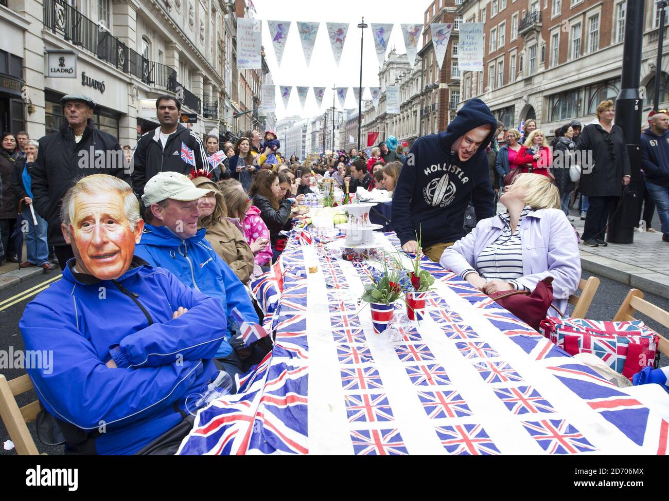 Revellers enjoy picnics at a giant table during the Big Lunch jubilee celebrations on Piccadilly in central London which was closed to traffic for the day for a street party Stock Photo