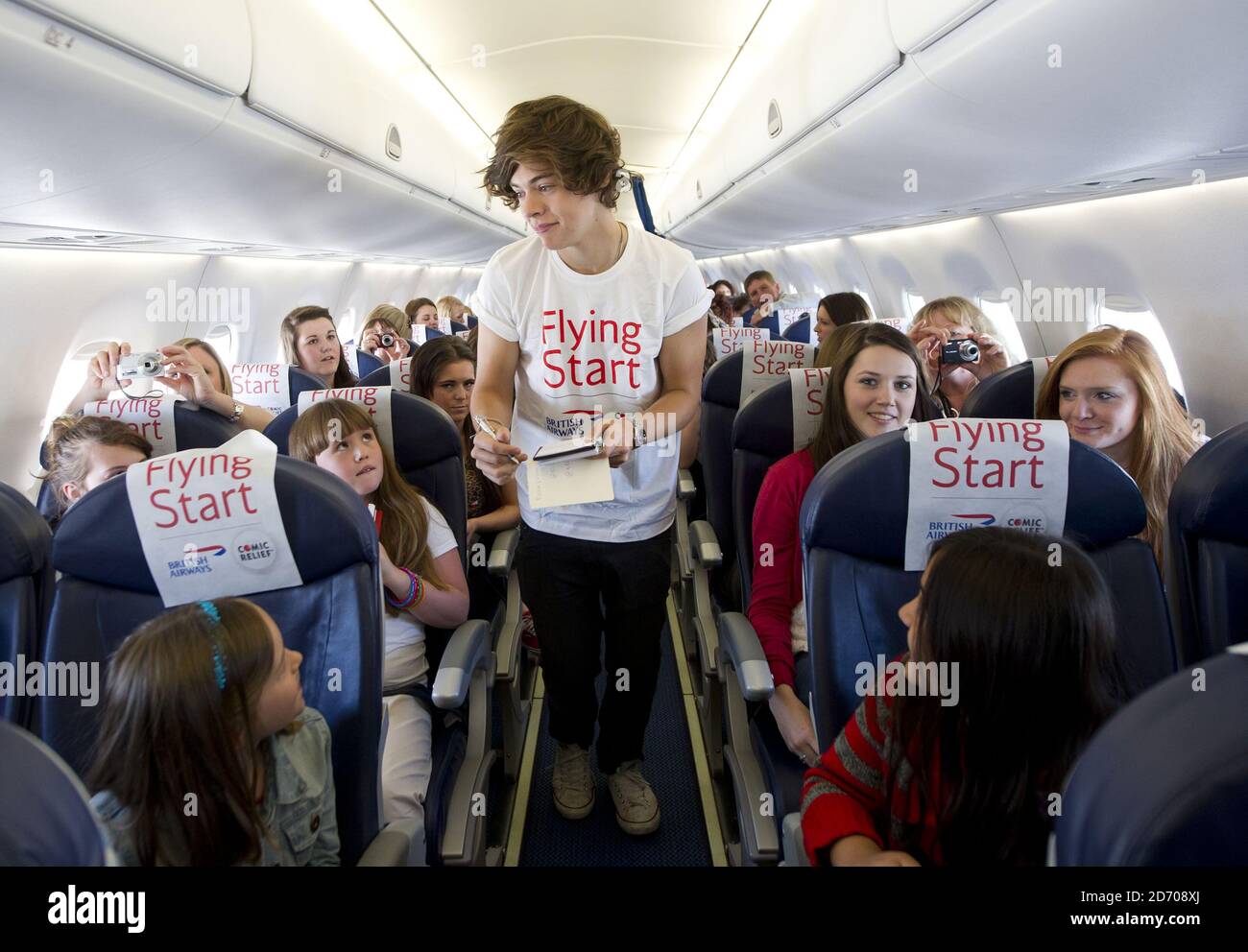 Harry Styles Of One Direction Pictured On Board Flight Ba1d A Private Charter Flight From London To Manchester Hosted By The Band For Competition Winners Which Raised A 50 000 For Flying Start