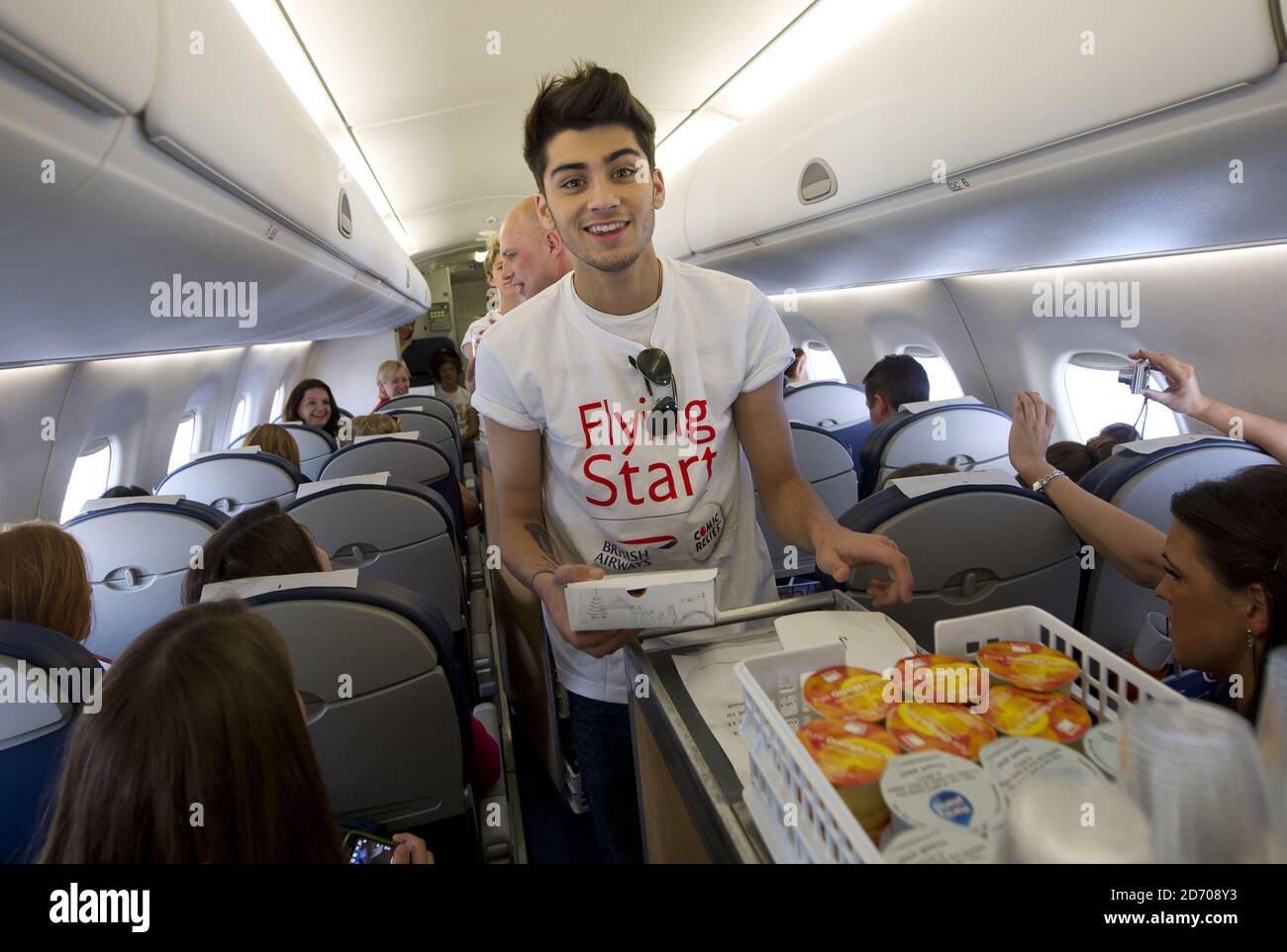 Zayn Malik Of One Direction Serves Drinks On Board Flight Ba1d A Private Charter Flight From London To Manchester Hosted By The Band For Competition Winners Which Raised A 50 000 For Flying