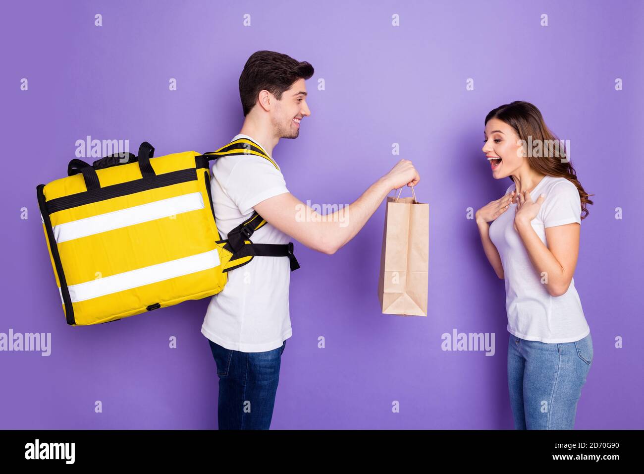 Profile photo amazed overjoyed lady courier guy hold present bag delivery speed best service quarantine birthday house order wear t-shirts jeans Stock Photo