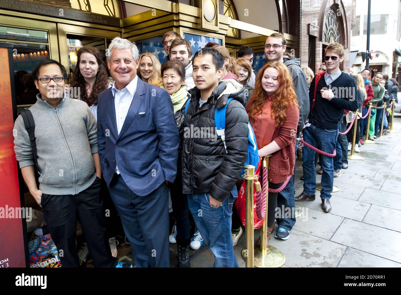 Producer Cameron Mackintosh welcomes theatre-goers queuing for Miss Saigon tickets, at the Prince Edward theatre in central London. Tickets for the show (opening May 2014) went on sale at 10am today, and sales set a new record for the largest single day of sales in West End and Broadway history. Stock Photo