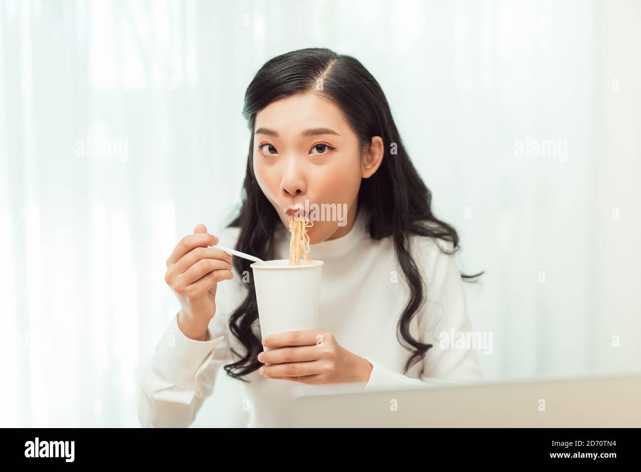 Late dinner. Girl eating instant noodles cup buy with great appetite