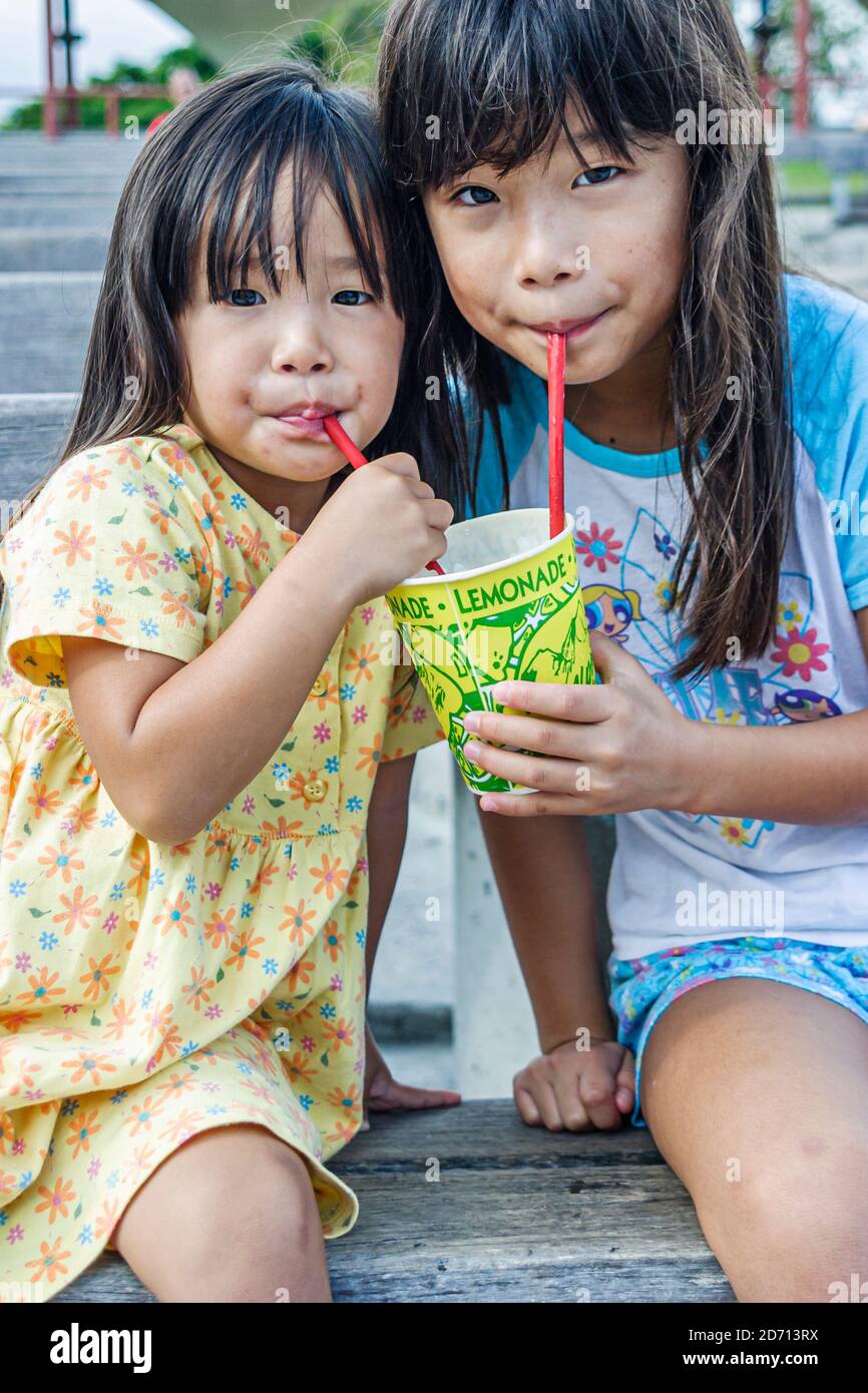 Miami Florida,Bayfront Park Japanese Festival annual Asian girl girls kid kids children sisters siblings,drinking straw straws, Stock Photo