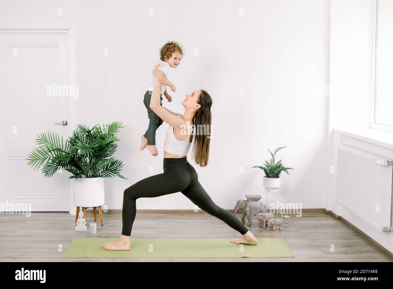 Mother and little son in sportswear doing yoga together at home. Beautiful  young Caucasian mother practices yoga with her son, mom in yoga pose holds  Stock Photo - Alamy