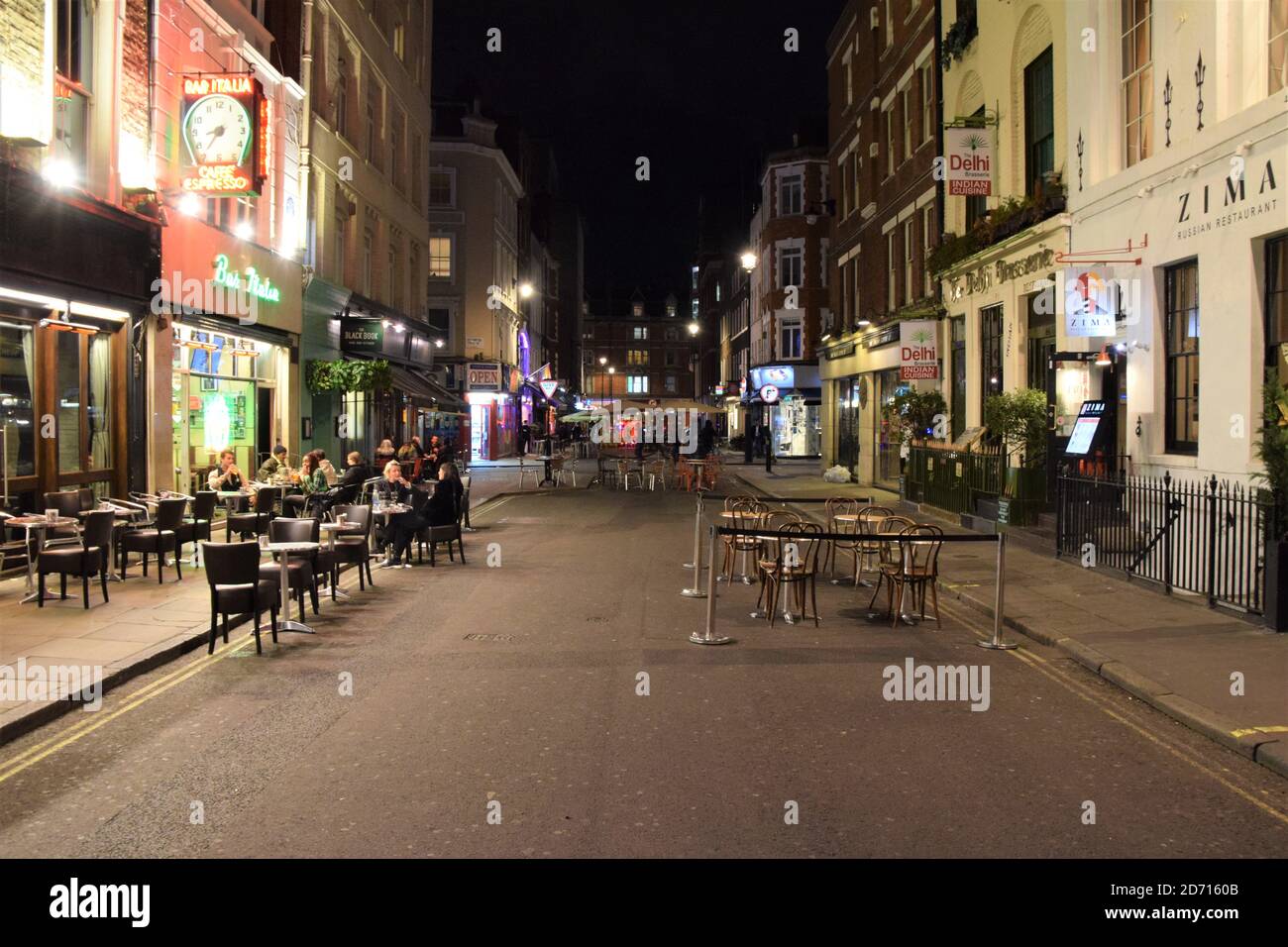 Empty restaurant tables on Frith Street, Soho, at night. New curfew and