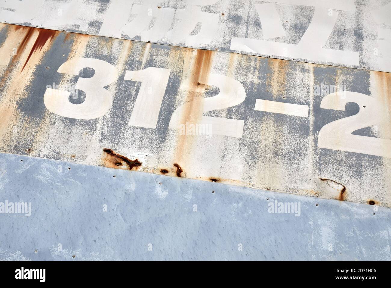 Numbers and Japanese text on partly rusty metal surface Stock Photo