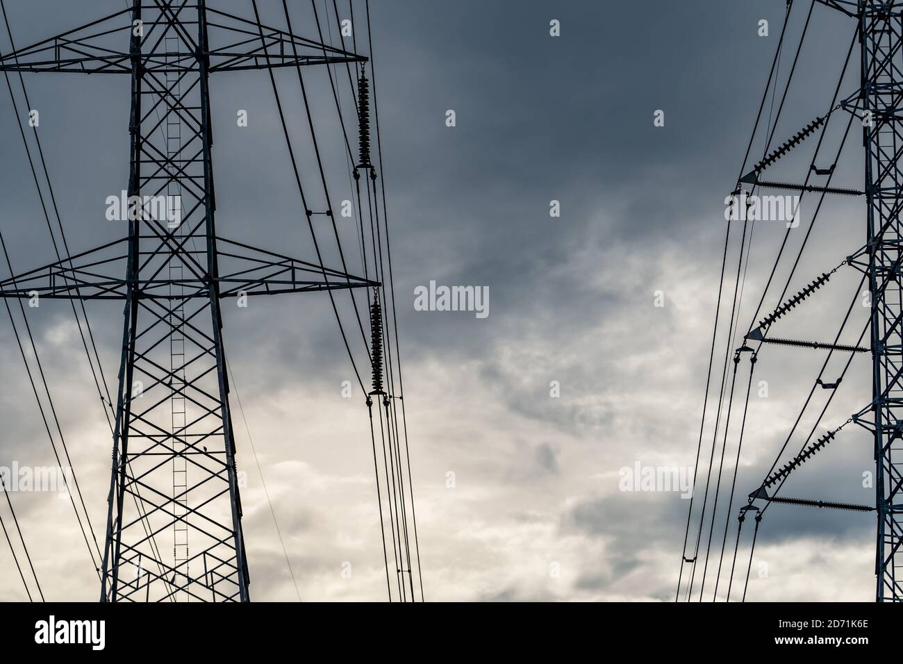 High voltage electric pylon and electrical wire against stormy sky and ...