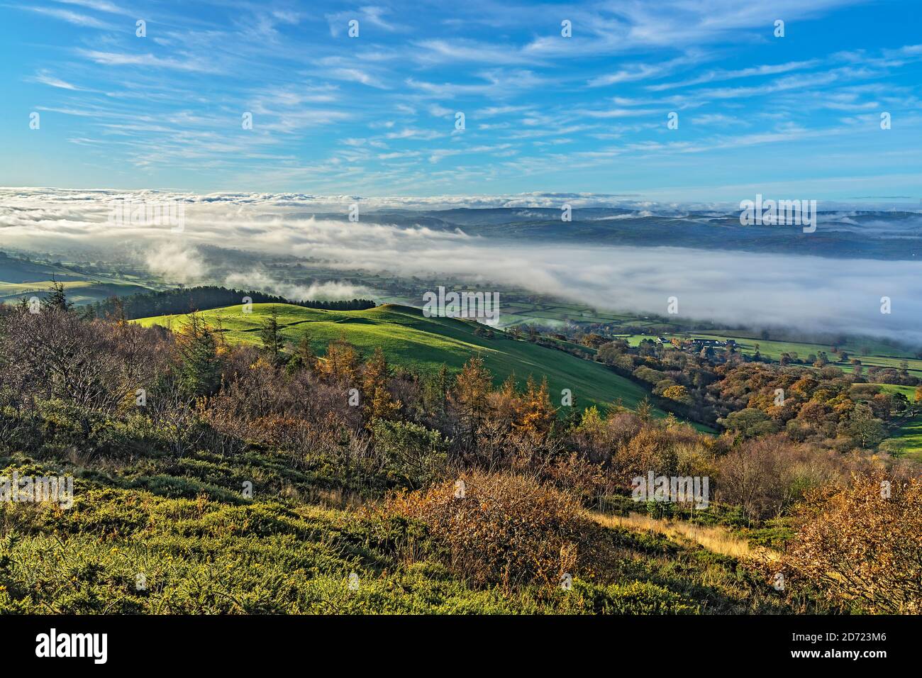 Lookimg west from slope of Pennycloddiau Mountain in the Clwydian Range in morning light with low cloud streaming down the Vale of Clwyd  North Wales Stock Photo