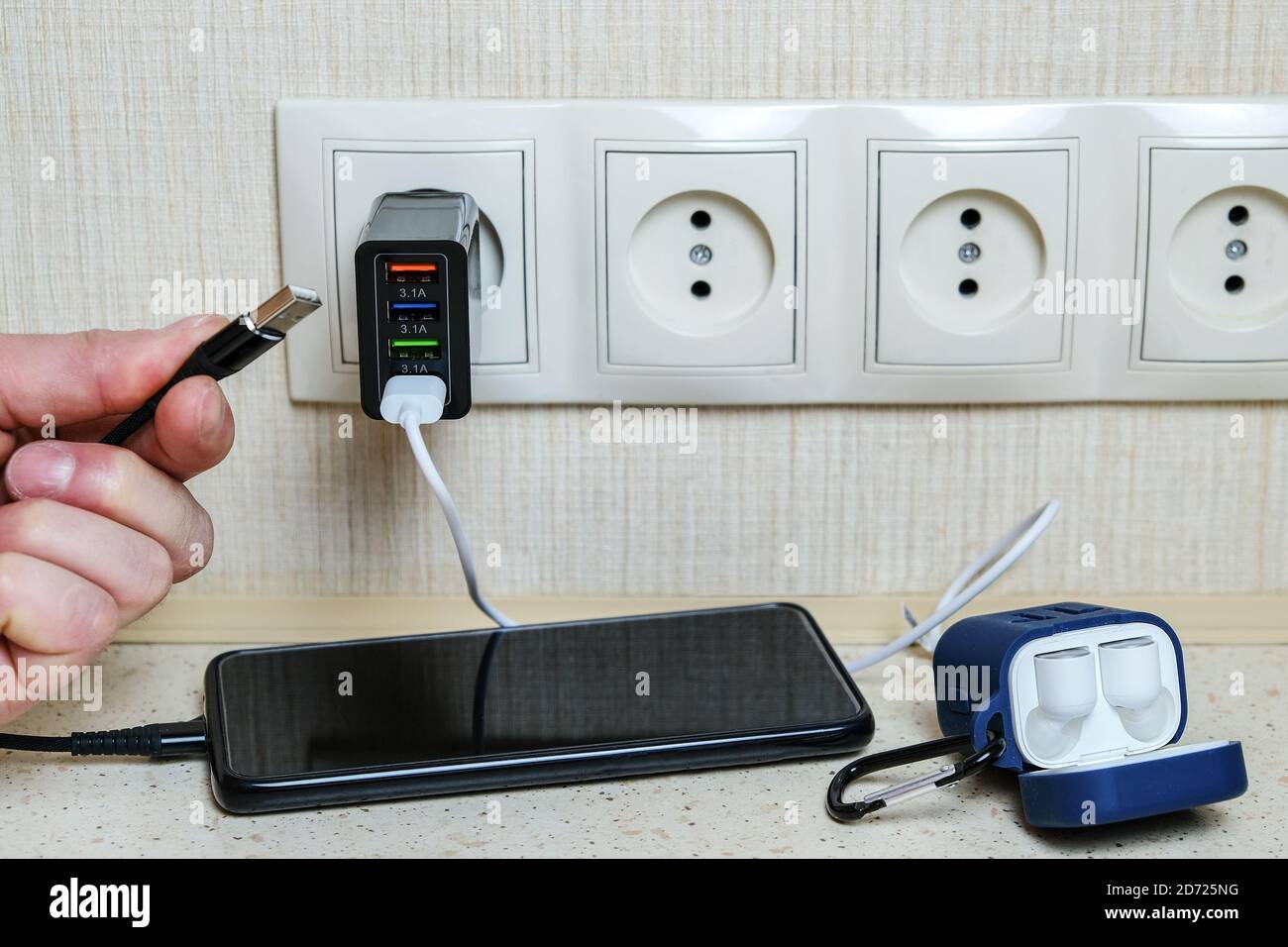 Multifunctional charger. Multiple USB ports. Charges your smartphone and wireless headphones. Stock Photo