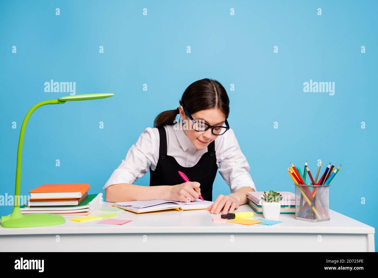 Photo of smart concentrated girl sit table write copybook high school  college project wear white black stylish trendy uniform overall isolated  over Stock Photo - Alamy