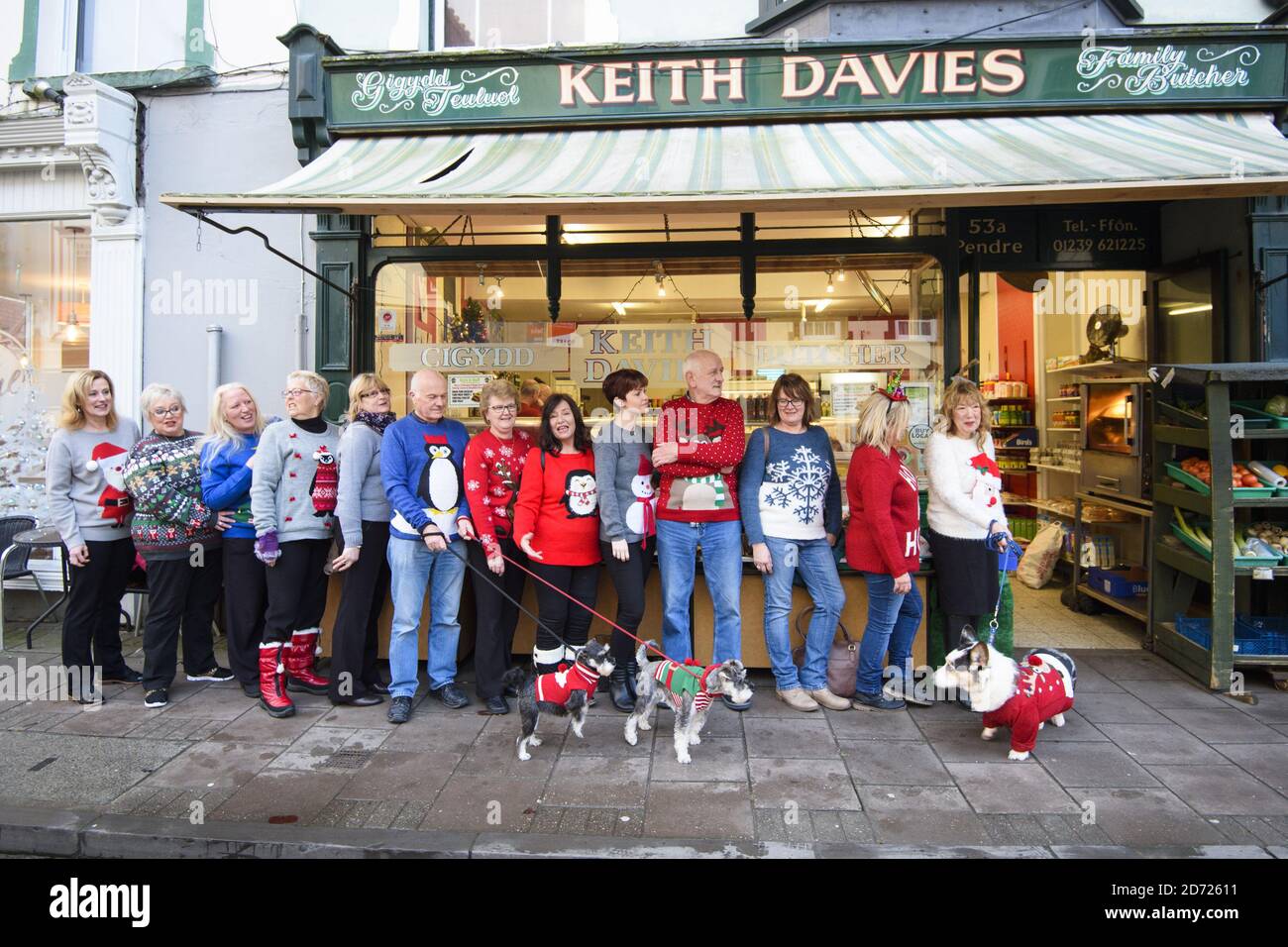 Residents queue for the butcher's shop wearing Christmas jumpers, as Cardigan in Wales officially changes its name to Jumper, to support Save the Children's Christmas Jumper Day, taking place this Friday 16th December. Picture date: Wednesday December 14th, 2016. Photo credit should read: Matt Crossick/ EMPICS Entertainment. Stock Photo