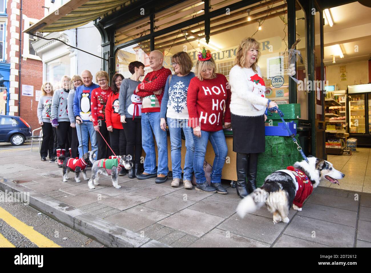 Residents queue for the butcher's shop wearing Christmas jumpers, as Cardigan in Wales officially changes its name to Jumper, to support Save the Children's Christmas Jumper Day, taking place this Friday 16th December. Picture date: Wednesday December 14th, 2016. Photo credit should read: Matt Crossick/ EMPICS Entertainment. Stock Photo